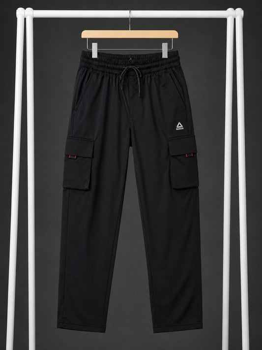 Black cargo pants with an elastic drawstring waist and side cargo pockets, hanging on a wooden hanger from a white clothing rack against a dark gray background.